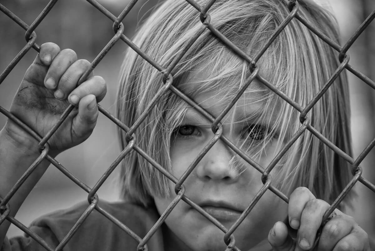 boy_looking_fence_chain_link_young_child_male_portrait-772750